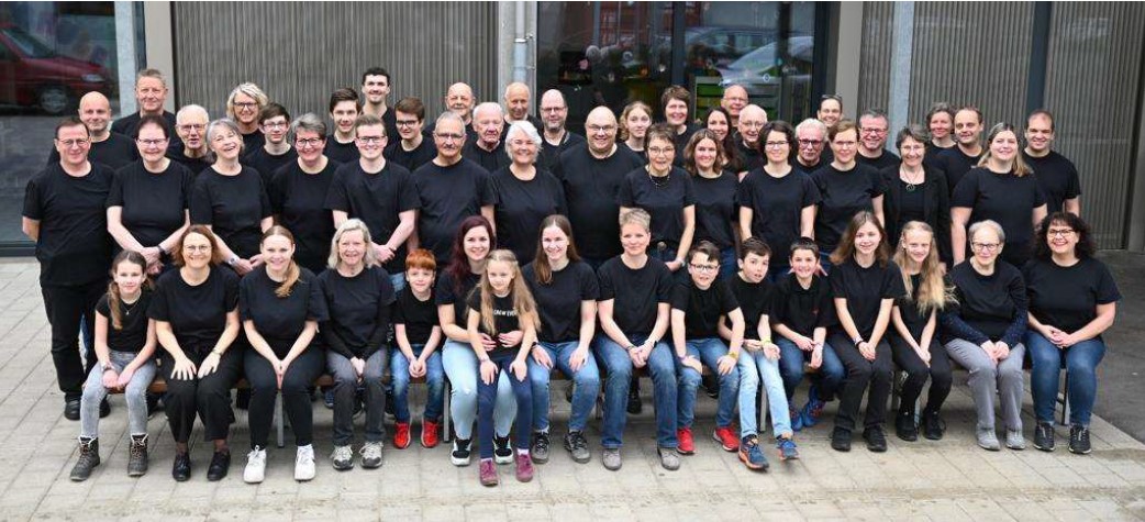 Gesamtbild der MG Uttigen - inkl. Projektteilnehmende - unter dem Baldachin beim Schulhaus Uttigen.