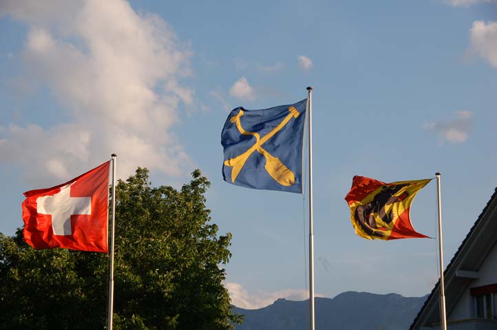 Schweizer-, Uttiger- und Berner Fahne wehen im Wind.