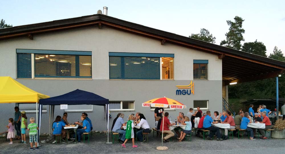 Unser Probelokal von aussen. Davor farbige Zelte und Sonnenschirme sowie Festbänke.