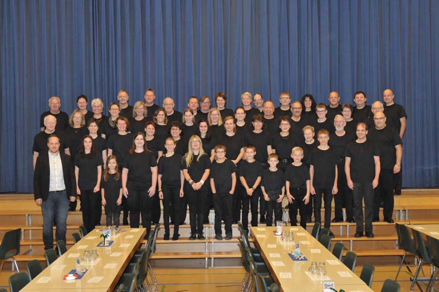 Die MGUttigen mit schwarzen T-Shirts auf der Treppe vor der geschlossenen Bühne.