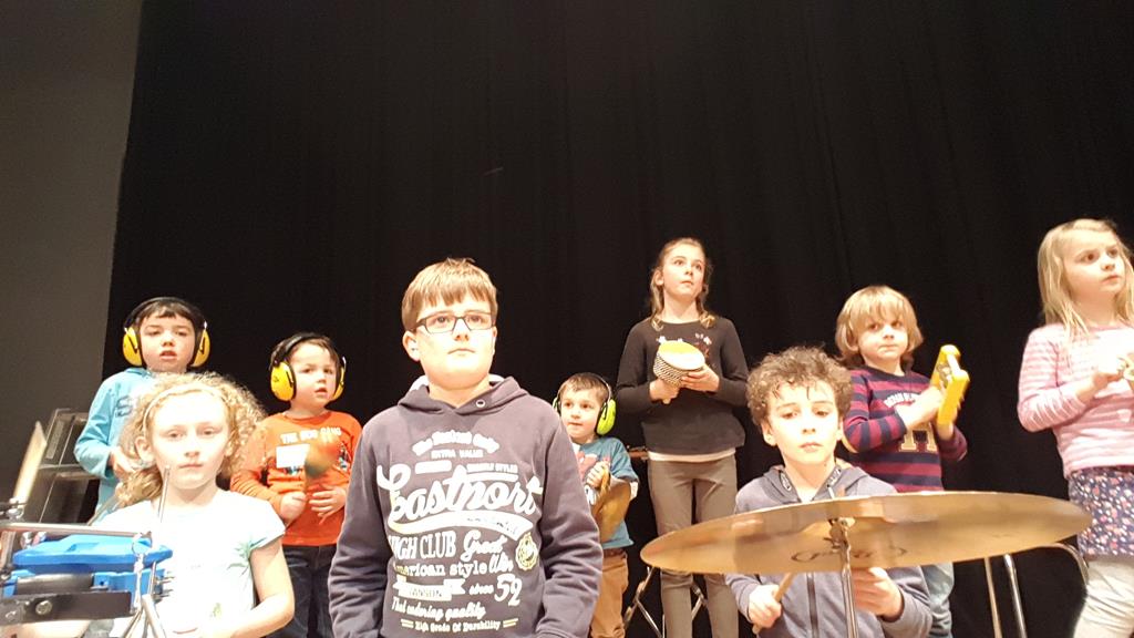 Begeisterte Kinder mit Rhythmusinstrumenten.