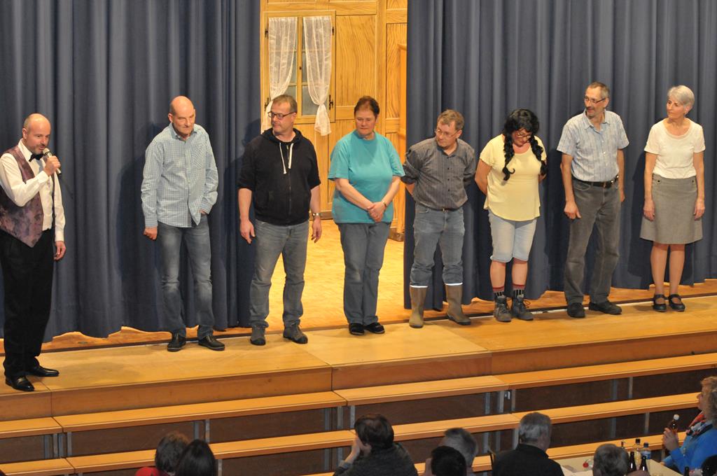 Die Theaterleute stehen vor dem fast geschlossenen Vorhang und nehmen den Dank unseres Präsidenten Oliver Hofer entgegen.