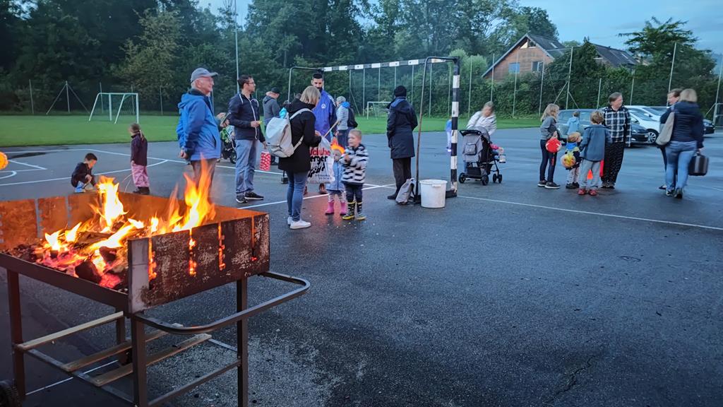 Grillfeuer und herumstehende Personen auf dem Pausenplatz.
