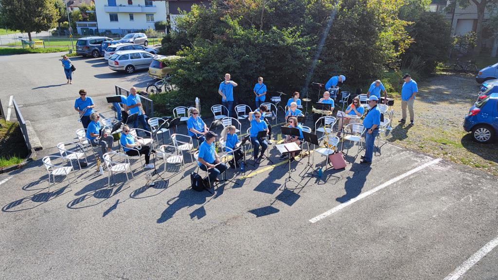 Die MGU sitzt im Halbkreis auf dem Parkplatz des Restaurants Säge in Uttigen. (Von oben von der Terrasse aufgenommen)