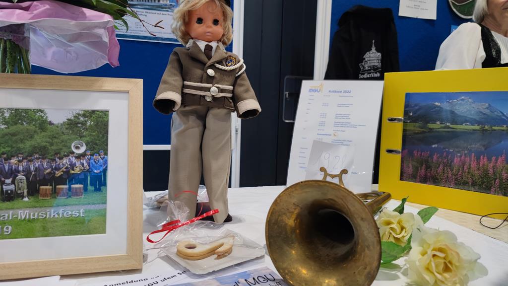Fotos der MGU auf einem Tisch. Auch eine Puppe mit der alten Uniform und ein altes Blasinstrument liegen darauf.