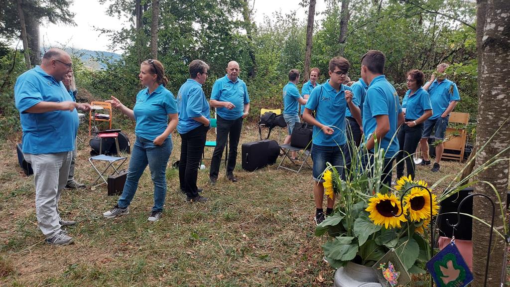 MGUler mit blauen T-Shirts stehen herum.